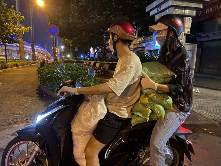 Hoa hậu Trần Tiểu Vy đi xe máy trao 3 tấn gạo cho người nghèo, người vô gia cư tại TP.HCM - Ảnh 1.