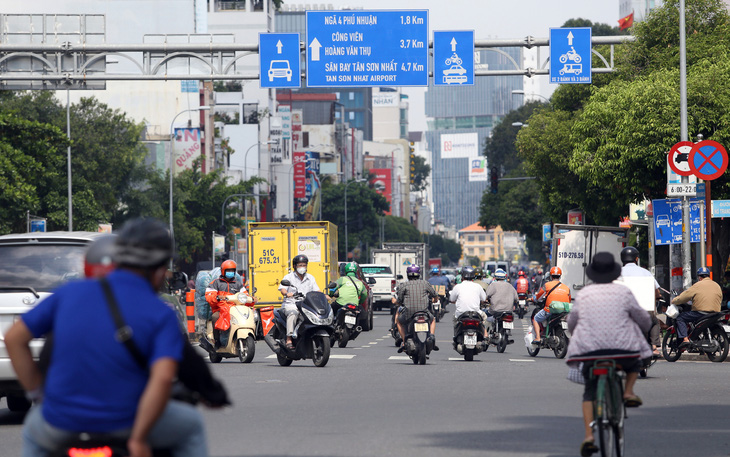 Gần trưa, đường phố TP.HCM vẫn đông người đi lại - Ảnh 3.