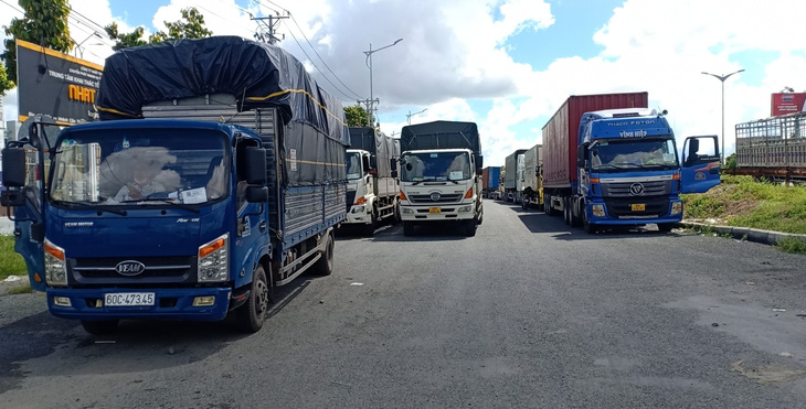 Hàng chục xe chở hàng thiết yếu bị kẹt tại chốt do quy định phải xuống hàng sang xe - Ảnh 1.