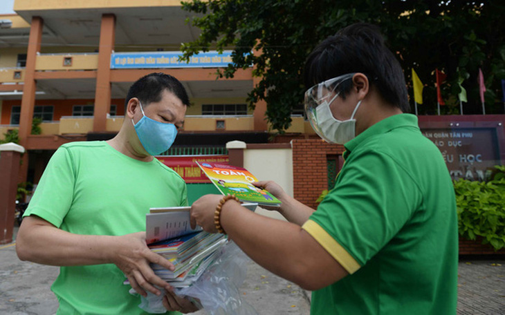 Đoàn thanh niên giúp đưa sách giáo khoa và đồ dùng học tập đến từng nhà học sinh - Ảnh 1.