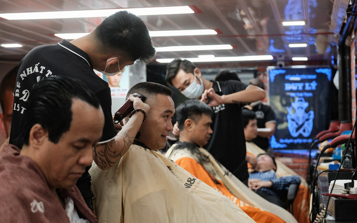 Tiệm cắt tóc vỉa hè, salon tóc đông kín khách ngày đầu mở lại