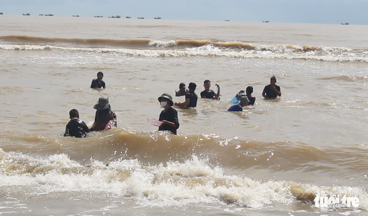 Cả trăm người đi vớt ‘lộc biển’ dạt vào bờ sau mưa bão - Ảnh 1.