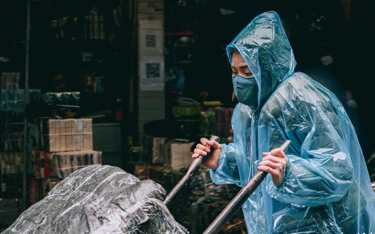 Người lao động ở Hà Nội trùm áo mưa, đốt lửa chống rét để mưu sinh