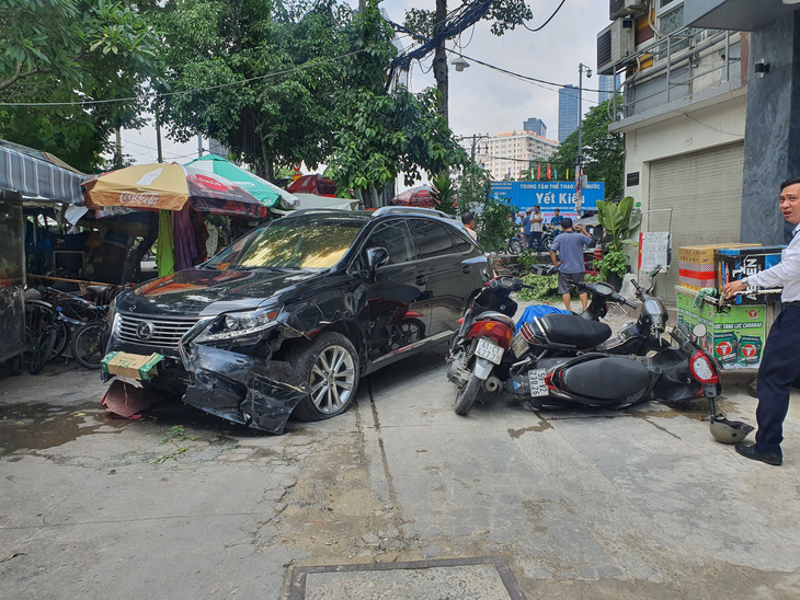 Xe bốn chỗ tông văng nhiều xe máy, người bán nước nhảy hàng rào thoát thân - Ảnh 1.