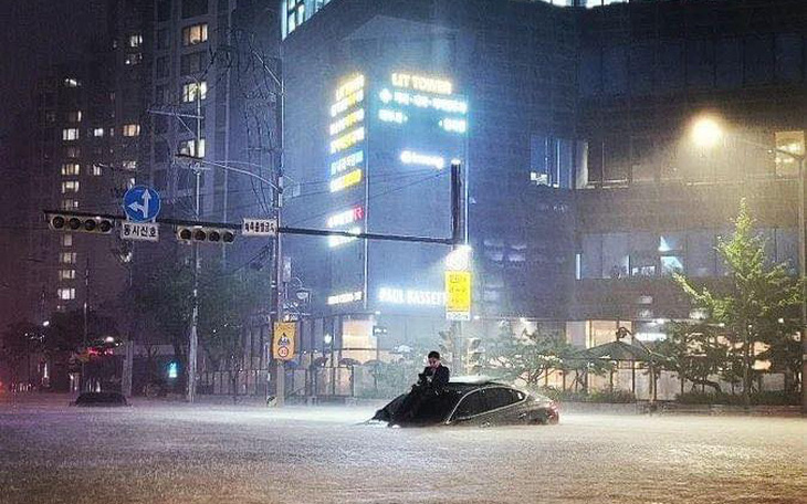 Ảnh gây bão mạng trong trận mưa lịch sử ở Seoul: Người đàn ông bị kẹt trên nóc xe sang