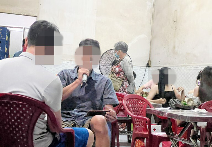 Một thực khách thoải mái hát karaoke giữa quán ốc ở huyện Hóc Môn, TP.HCM, bất chấp người khác thích hay khó chịu - Ảnh: MÂY TRẮNG