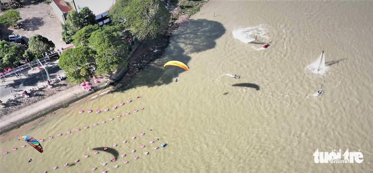 Người dân chen kín bờ kè sông Tiền xem flyboard, dù lượn - Ảnh 5.