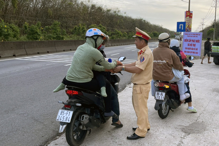 Cảnh sát giao thông Đồng Nai đội nón bảo hiểm cho trẻ về quê đón Tết - Ảnh 3.