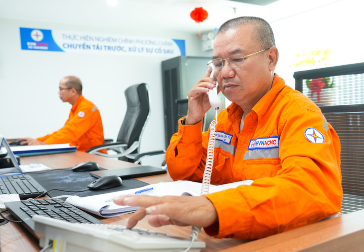 Anh Lê Tuấn Tú, Tổ phó tổ Vận hành 4, Công ty Điện lực Tân Bình, EVNHCMC điện thoại điều hành anh em sửa chữa điện - Ảnh:HỮU HẠNH