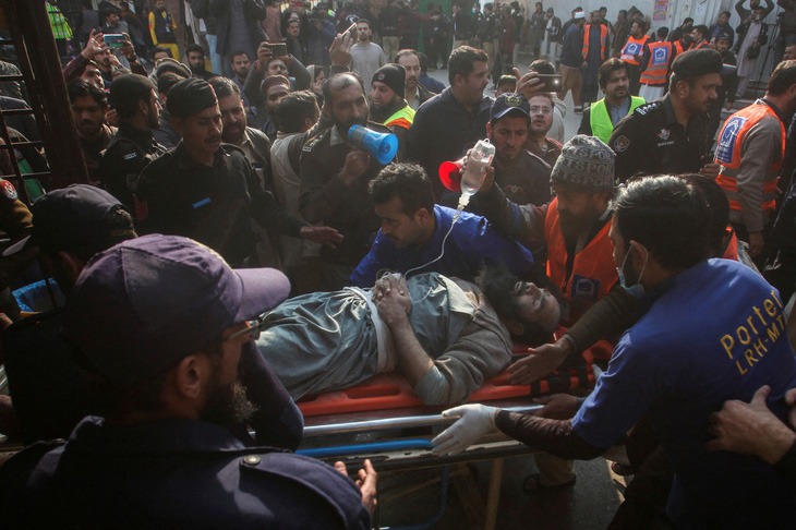 Người bị thương trong vụ nổ được đưa vào bệnh viện ở Peshawar, Pakistan, ngày 30-1 - Ảnh: REUTERS
