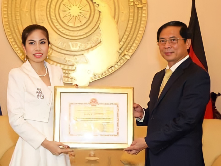 Bộ trưởng Bộ Ngoại giao Bùi Thanh Sơn trao tặng giấy khen cho chị Phan Mỹ Hà vì đã có thành tích xuất sắc trong công tác phòng chống dịch COVID-19 và ủng hộ đồng bào miền Trung bị bão lũ - Ảnh: NVCC