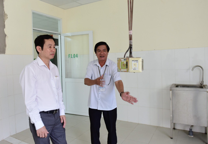 Bác sĩ Trần Văn Khanh (trái) cùng bác sĩ Đoàn Ngọc Huệ kiểm tra đường dẫn hệ thống phòng ốc tại Bệnh viện Cần Giờ vào cuối tháng 8-2023 - Ảnh: DUYÊN PHAN