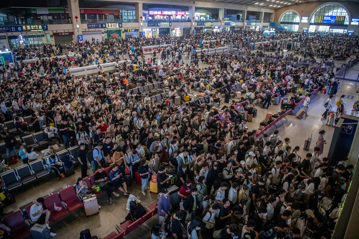 Hành khách ngồi la liệt tại ga xe lửa Hán Khẩu ở thành phố Vũ Hán, Trung Quốc để chờ tàu đi du lịch. Hàng chục triệu người Trung Quốc sẽ đi du lịch trong kỳ nghỉ thu 8 ngày năm nay, bắt đầu từ 29-9. Đây là kỷ nghỉ dài ngày nhất kể từ sau khi Trung Quốc gỡ bỏ những hạn chế phòng COVID-19 vào tháng 12-2022 - Ảnh: AP