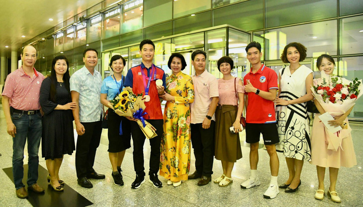 Bố mẹ, người thân ra đón Quang Huy tại sân bay - Ảnh: TDTT