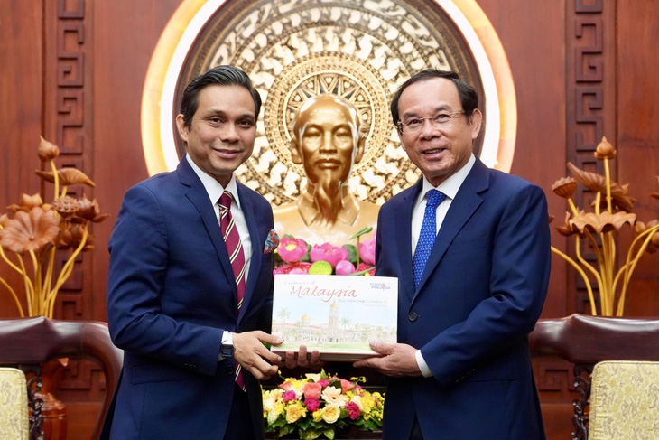 Ông Nguyễn Văn Nên nhận quà lưu niệm từ tân Tổng lãnh sự Malaysia tại TP.HCM Firdauz Bin Othman - Ảnh: HỮU HẠNH