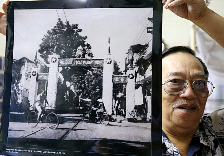 Nhiếp ảnh gia Trịnh Đình Tiến và bức ảnh ông chụp Hà Nội ngày tiếp quản 1954  - Ảnh: QUỐC VIỆT