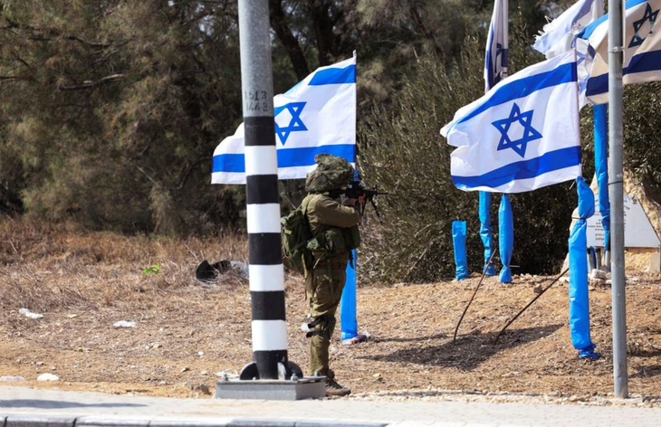 Binh sĩ Israel tại cổng vào khu định cư Kfar Aza - Ảnh: REUTERS