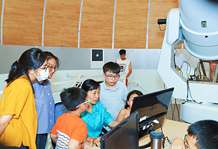 Tiến sĩ Nguyễn Thị Thảo hướng dẫn các em cách sử dụng kính thiên văn lớn nhất tại Đài Thiên văn học Nha Trang - Ảnh: TRẦN HOÀI