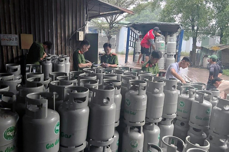 Lực lượng chức năng kiểm tra, bắt quả tang các nghi phạm sản xuất gas giả tại nhà kho công ty - Ảnh: Công an cung cấp