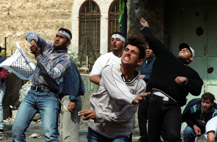 Người dân Palestine ném đá vào lực lượng an ninh Israel hồi tháng 10-2000, trong cuộc intifada lần hai - Ảnh: AFP