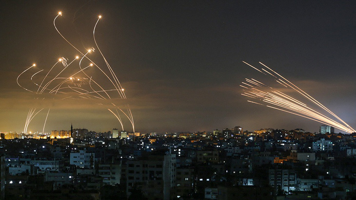 Rocket của lực lượng Hamas bắn từ Dải Gaza (trái) đối đầu với hệ thống phòng không Vòm Sắt của Israel - Ảnh: AFP