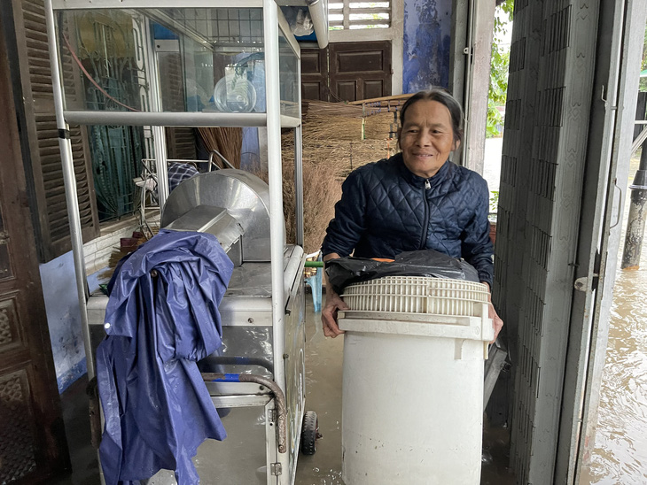 Bà Hồ Thị Duyên (trú đường Võ Trác, thị xã Hương Thủy, Thừa Thiên Huế) kê cao đồ đạc để tránh nước lũ đang tràn vào nhà - Ảnh: BẢO PHÚ