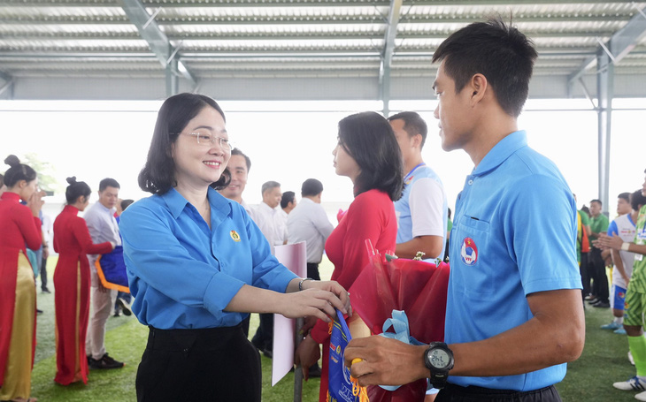 Bà Nguyễn Kim Loan - chủ tịch Liên đoàn Lao động tỉnh Bình Dương - tặng hoa cho trọng tài trước giờ khởi tranh - Ảnh: HỮU HẠNH