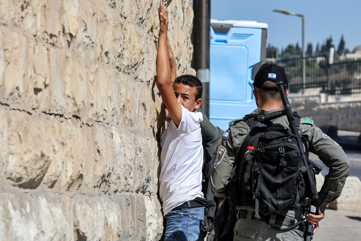 Binh sĩ Israel lục soát người thanh niên Palestine ở cổng Sư Tử, khu vực thành cổ Jerusalem, ngày 13-10 - Ảnh: AFP