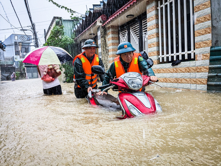 Lực lượng cứu hộ cứu nạn hỗ trợ di chuyển tài sản của người dân ở nơi bị ngập lụt - Ảnh: TẤN LỰC