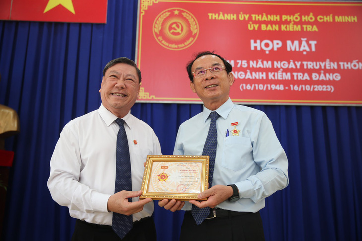 Phó chủ nhiệm thường trực Ủy ban Kiểm tra Trung ương Trần Văn Rón trao kỷ niệm chương “Vì sự nghiệp kiểm tra của Đảng” cho Bí thư Nguyễn Văn Nên - Ảnh: TIẾN LONG