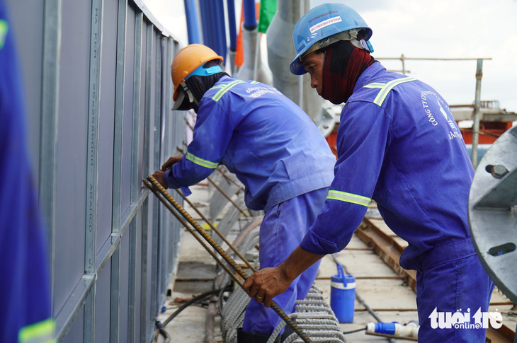 Công nhân thi công tại dự án cầu Mỹ Thuận 2 ngay trong ngày hợp long nhằm đảm bảo dự án đúng tiến độ - Ảnh: MẬU TRƯỜNG