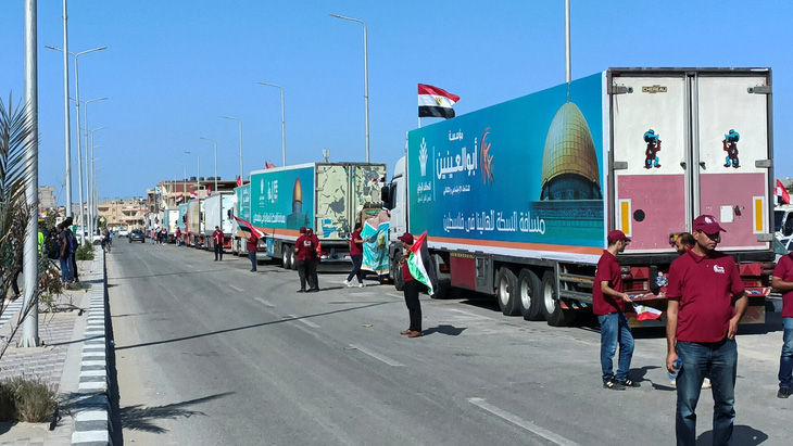 Các tình nguyện viên Ai Cập chờ đợi bên cạnh đoàn xe tải chở hàng viện trợ nhân đạo cho người Palestine của các tổ chức phi chính phủ ở thành phố Al-Arish, bán đảo Sinai của Ai Cập, ngày 15-10 - Ảnh: REUTERS