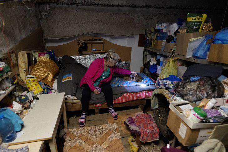 Người phụ nữ sống cùng thú cưng trong hầm một tòa nhà bị hư hại ở Avdiivka, vùng Donetsk - Ảnh: AFP