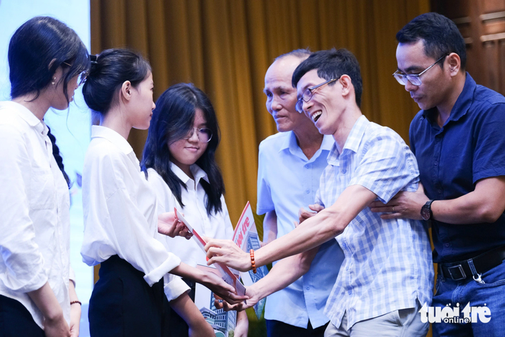 Anh Nguyễn Hoàng Gia Bảo trao quà cho các tân sinh viên. Bảo bị bại não, từng là sinh viên nhận học bổng Tiếp sức đến trường năm 2009, nay trở thành kỹ sư IT - Ảnh: TẤN LỰC - Ảnh: TẤN LỰC