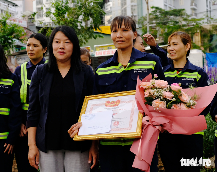 Bà Trần Thị Vũ Loan (bên trái), phó chủ tịch UBND TP Đà Lạt, ra nơi chị Vũ Thị Thu quét rác để trao giấy khen và quà từ UBND TP - Ảnh: M.V