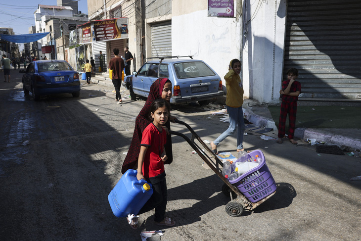 Người Palestine mang theo chai và thùng rỗng để tìm nước sạch tại trại tị nạn Rafah, phía nam Dải Gaza, ngày 15-10 - Ảnh: AFP