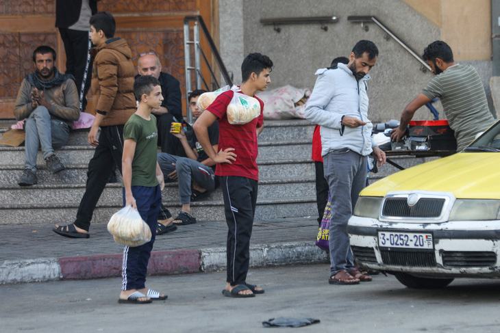 Người Palestine mua bánh mì ở thành phố Gaza, ngày 16-10 - Ảnh: AFP