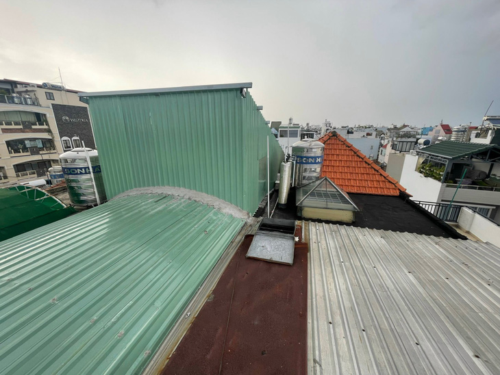 Phần sân thượng nhà hàng xóm của bà Hồ Thị Sáu thời điểm mới xây 'lụi' là nhà tôn góc trái ảnh - Ảnh: N.V.