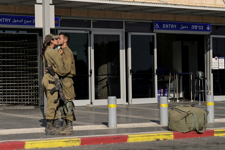 Hai người lính Israel hôn nhau bên một nhà ga xe lửa, trong bối cảnh xung đột đang diễn ra giữa Israel và Hamas ở Ashkelon, miền nam Israel, ngày 16-10 - Ảnh: REUTERS