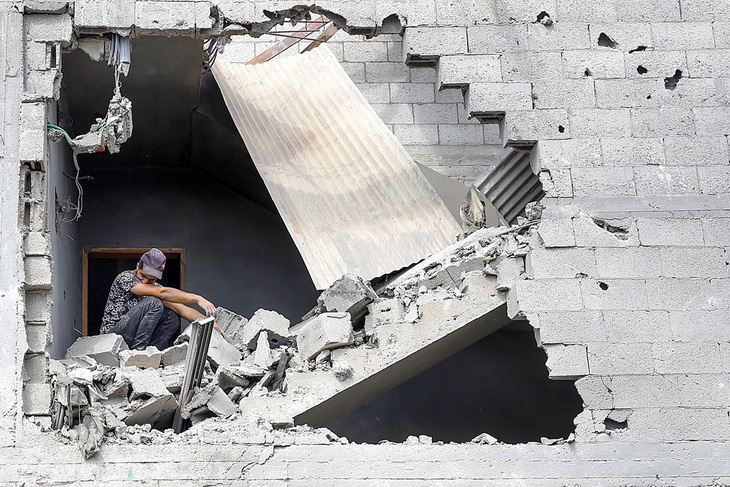 Một người đàn ông ngồi trong ngôi nhà bị phá hủy do các cuộc tấn công trả đũa của Israel ở thành phố Khan Younis, phía nam Dải Gaza, vào ngày 16-10 - Ảnh: Reuters