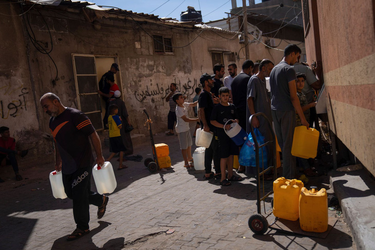 Người dân xếp hàng lấy nước tại một trạm cấp nước ở thành phố Khan Younis, miền nam Gaza - Ảnh: WALL STREET JOURNAL