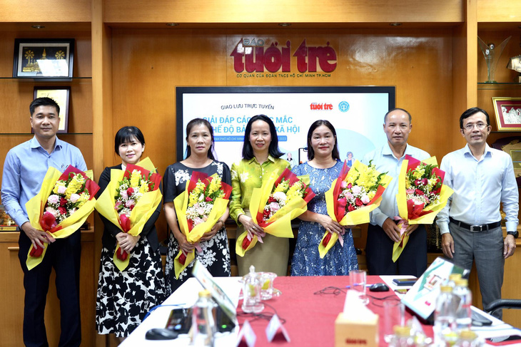 Phó tổng biên tập báo Tuổi Trẻ Trần Xuân Toàn (bìa phải) tặng hoa cho các khách mời tham dự chương trình - Ảnh: HỮU HẠNH