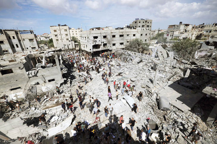 Nhà cửa bị phá hủy, người dân đang tìm kiếm nạn nhân sau cuộc không kích của Israel vào TP Rafah, phía nam Dải Gaza, ngày 17-10 - Ảnh: AFP