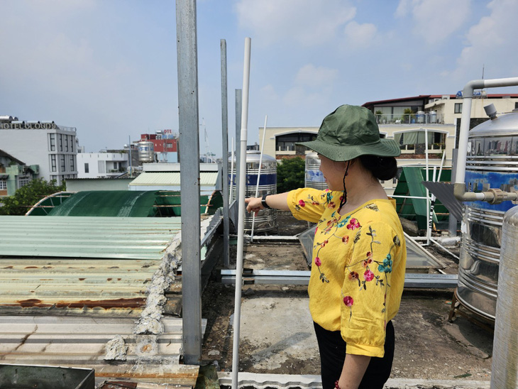 Phần công trình xây 'lụi' trên sân thượng nhà hàng xóm của bà Hồ Thị Sáu vẫn chưa hoàn tất tháo dỡ, vẫn còn các khung sắt - Ảnh: ÁI NHÂN