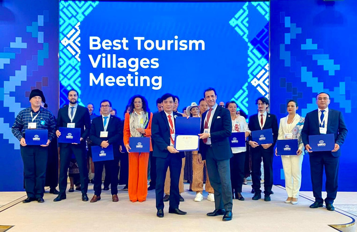 Đại diện xã Tân Hóa được Tổ chức Du lịch thế giới trao giấy chứng nhận Làng du lịch tốt nhất thế giới vào chiều 19-10 - Ảnh: D.L