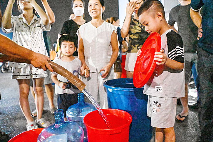 Người dân khu đô thị Thanh Hà xuyên đêm chờ lấy nước sạch từ xe téc - Ảnh: HỒNG QUANG