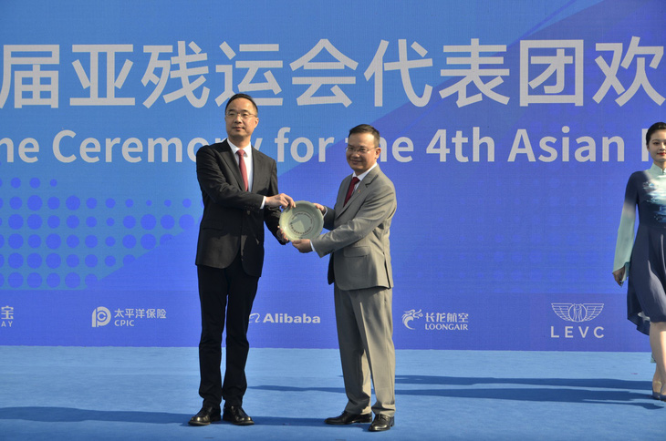 Trưởng đoàn Nguyễn Hồng Minh (phải) tặng quà lưu niệm cho Ban tổ chức Asian Para Games 4 - Ảnh: THÁI DƯƠNG