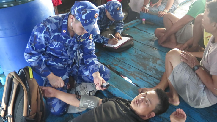 Lực lượng cảnh sát biển tiếp cận, khám sức khỏe cho các ngư dân của tàu QNa 90129 - Ảnh: M.T.