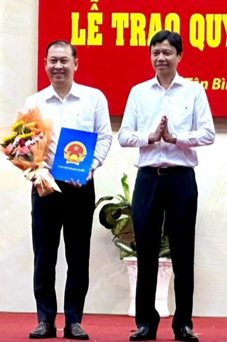 Ông Nguyễn Bá Thành, chủ tịch UBND quận Tân Bình, TP.HCM, trao quyết định bổ nhiệm trưởng Phòng Giáo dục và Đào tạo cho ông Phan Văn Quang (trái) - Ảnh: GIA HUY