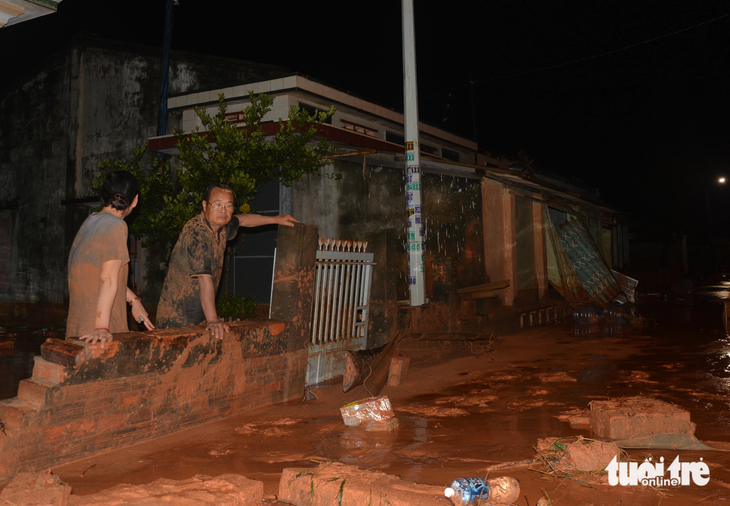 Vợ chồng ông Huỳnh Văn Đệ ở thôn Tiến Phú, xã Tiến Thành thất thần nhìn căn nhà ngổn ngang trong cát đỏ